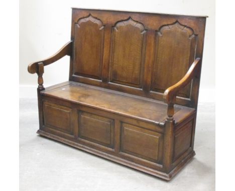 A reproduction oak panel back bench, with hinged seat, 123cm wide  