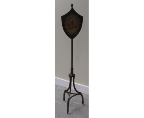 A George III style mahogany fire screen with shield shaped screen painted with cherubs  