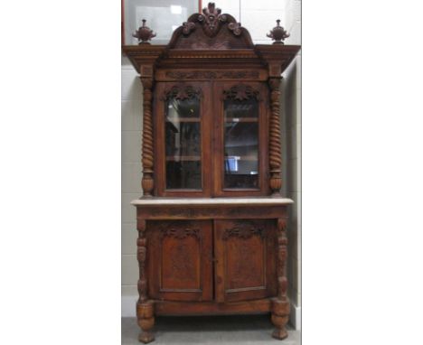 An Anglo-Indian almirah cupboard with carved pediment, glazed doors, a marble shelf and cupboards below, 110cm wide  