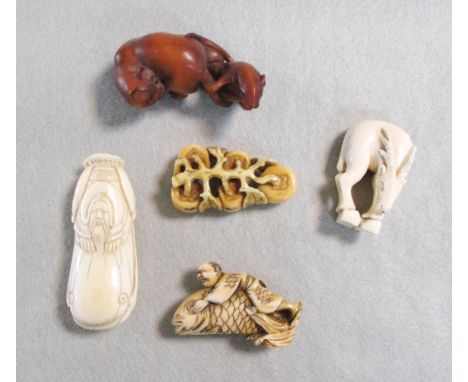 A group of five netsuke, first half of the 20th century, including four in ivory: a branch with persimmon fruits 4.4cm, a sag