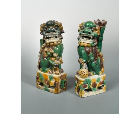 A pair of Kangxi green, yellow and brown/aubergine glazed buddhistic lion joss stick holders, modelled in mirror image, seate