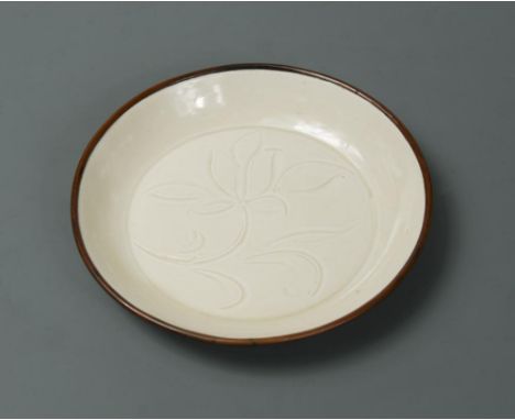 A Song dynasty small carved Ding ware dish, carefully moulded with a flat base and shallow slightly rounded sides, the interi