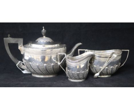 A late Victorian silver three piece tea set by Edward Hutton, London, 1893 and a pair of Irish silver sugar tongs, gross 28oz