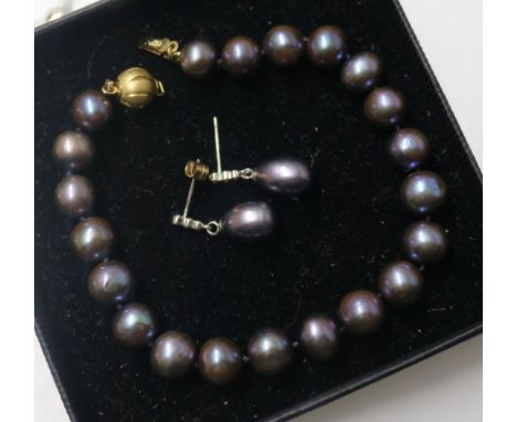 A pair of white metal Tahitian cultured pearl and diamond set drop ear studs and a similar bracelet with gold plated clasp.