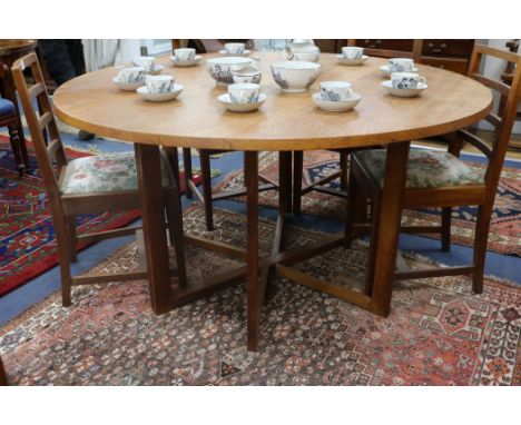 A Gordon Russell oak circular drop leaf dining table with gate leg action underframe Top 143cm Diameter