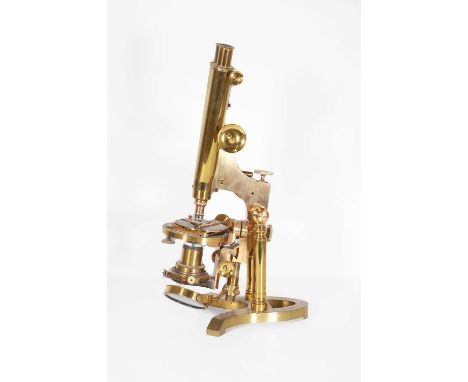 A brass binocular microscope, late 19th to early 20th century, raised on an integral brass plinth, stamped 'Ross 5180 London'