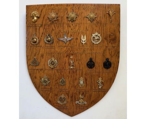 20 Guards, Special Forces &amp; Corps cap badges mounted on shield.   Good selection beautifully mounted on varnished wooden 