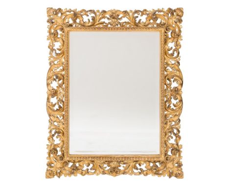 A 19th Century carved giltwood Florentine rectangular mirror:, the bevelled plate within a fluted slip and pierced acanthus s