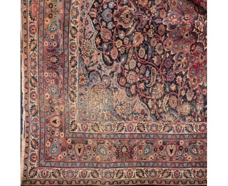 A Tabriz carpet:, the indigo cartouche field with a central rose geometric flowerhead medallion, all over palmette, lanceolat