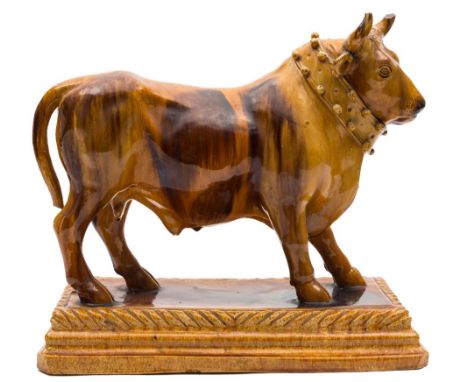A Portuguese majolica 'decanter' figure of a bull: by Mafra, Caldas de Rainha, decorated in treacle glazes, the animal standi