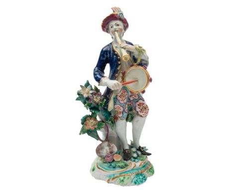 A Bow figure of a musician: wearing a plumed hat, blue jacket and floral breeches, playing a flageolet and tabor, on bocage t