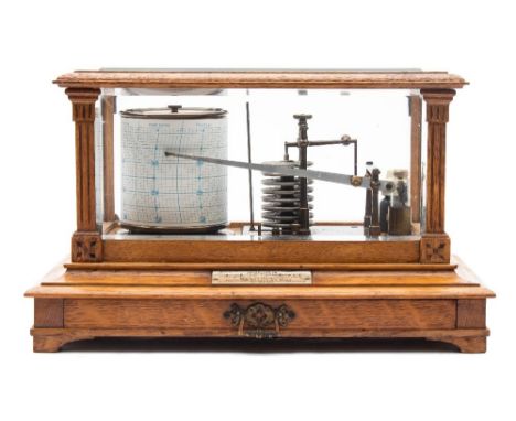 Short & Mason, London, an oak cased barograph: the glazed oak case having flat fluted columns to the corners, with a sheet dr