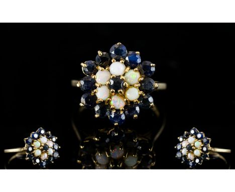 A 9ct Gold Cluster Ring Set with central sapphire surrounded by six opals, surrounded by a further twelve sapphire, fully hal