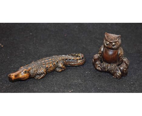 A Japanese hardwood netsuke, carved as an alligator, 9cm long; another, of an owl, perched on a branch, 4.4cm high, [2] 