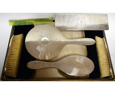 A George V silver six-piece lady's dressing table set, comprising a hand brush, a hand mirror, two rounded rectangular brushe
