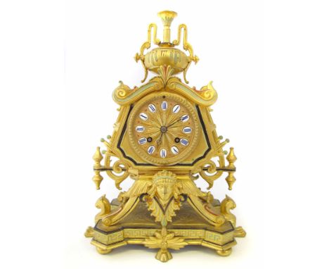 A 19th century French Egyptian revival style mantel clock, the shaped base raised on four bun feet and with two beast support