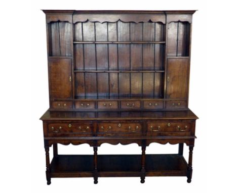 20th century oak dresser of George III design, two shelf rack containing two cupboards and six spice drawers, base with three