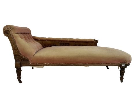 Victorian chaise longue, the walnut frame with buttoned back red fabric raised on turned supports, terminating in ceramic cas