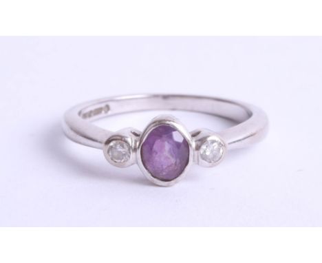 An 18ct white gold amethyst and diamond set three stone ring, size K.