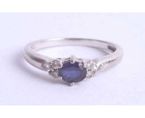 An 18ct white gold ring set with a central sapphire and six small diamonds, size K.