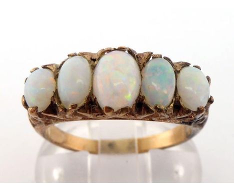 A five stone opal ring, composed of five graduated opals, above a scrolling gallery mount (tests 9 carat gold), finger size O