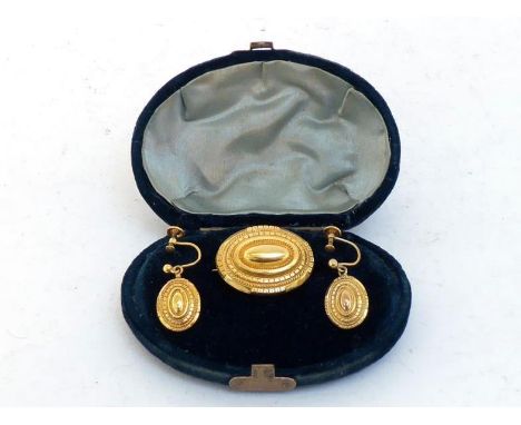 A Victorian gold plated brooch and earring suite, of oval punched design, the brooch 3cm long, glazed panel verso, the earrin