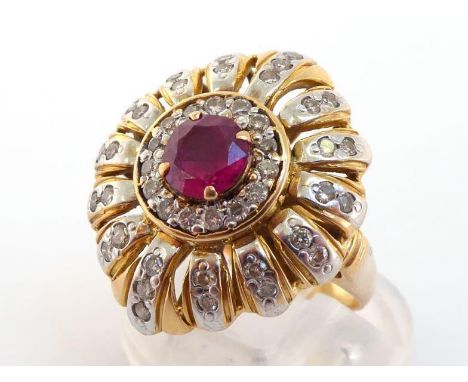 A ruby and diamond cluster ring, the central round-cut stone 5.8mm diameter, in a radial surround studded with small brillian