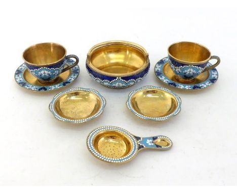 A Soviet Russian cloisonne enamel  and silver-gilt teaset comprising:- a swing-handled sugar bowl, two teacups and saucers, a