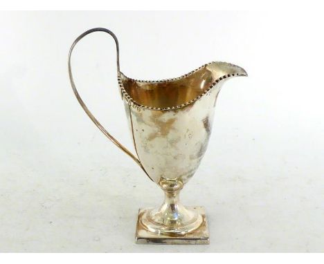 A George III silver helmet cream jug by Thomas Law, Sheffield, 1796, with reeded loop handle, square pedestal foot and revers