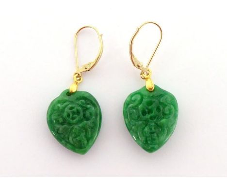 A pair of carved jade earrings, the jade spade shaped pendants 20mm long, the gold hook fittings stamped '9k', 6.6gms 