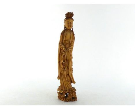 A Chinese ivory carving of a Guanyin figure standing on a lotus flower base and holding a scroll and a string of beads, 18th/