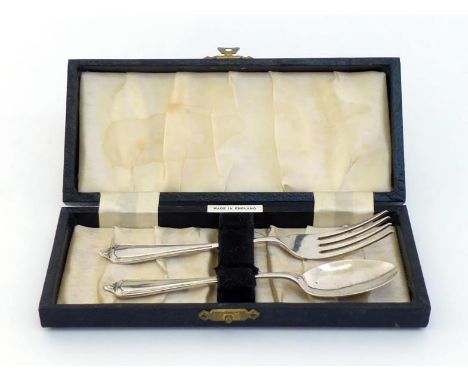 A boxed silver christening spoon and fork by William Adams, London 1959/60. In good condition, case a little rubbed, stain to