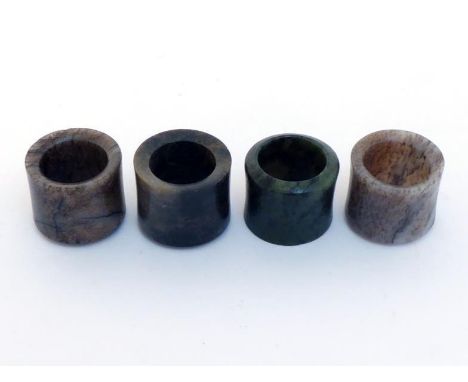 A group of four Chinese jade archer rings, of plain form, each in different colour of jade, one in green, one in grey, one in