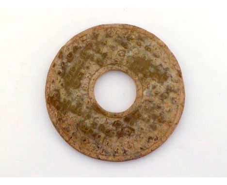 A Chinese archaic style carved jade pendant of Bi form. Carved with multiple “Chi” dragon on both side. with partial cream-co