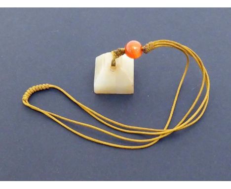 A Chinese carved white jade seal, square with tapering sides and domed top, the base plain, Ming or earlier, 1.7cm high, in g