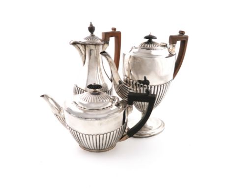 A Victorian silver coffee pot, by Carrington and Co., London 1886, oval form, part-fluted decoration, scroll handle, on a rai