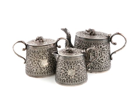 A three-piece Indian silver tea set, Cutch, circa 1900-1920, tapering circular form, chased foliate scroll decoration on a ma