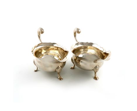 A pair of George III silver sauce boats, by John Pollock, London 1753, oval form, wavy-edge border, leaf capped flying scroll
