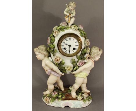 A 19TH CENTURY SITZENDORF PORCELAIN CLOCK formed with two opposing cherubs holding a flower encrusted and cherub-topped egg, 