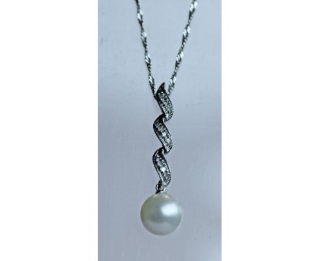 A 9K WHITE GOLD, DIAMOND CHIP AND PEARL PENDANT of foliate form with inset small diamond chips and suspended pearl drop, mark