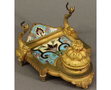 A 19TH CENTURY CONTINENTAL CHAMPLEVE ENAMEL AND GILT METAL INK STAND with enamelled panel and back between dolphin form pen s