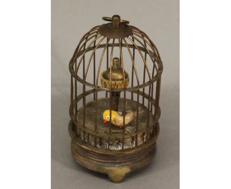 A BRASS-CASED NOVELTY CLOCK of bird cage form, the pointer revolving around a globular scale. 12cm(h) CONDITION: Some bending
