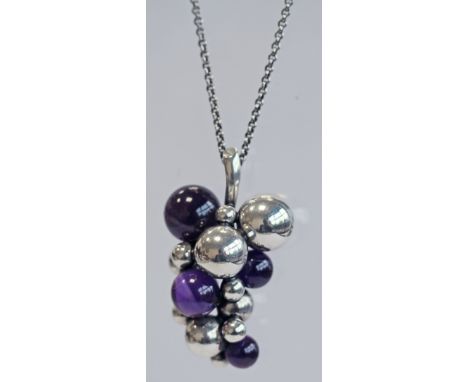 A GEORG JENSEN MIDNIGHT GRAPES PENDANT, a bunch of grapes with four graduating amethysts, suspended by a fine linked chain wi