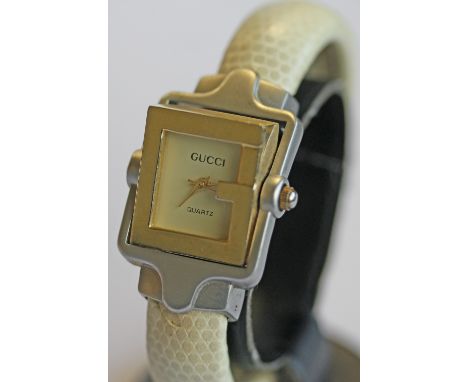 A LADIES PIVOTING TWIRL WRISTWATCH in the form of the letter G, marked Gucci in gilt, pivoted between a brushed metal surroun