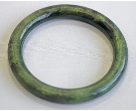 A JADE BANGLE, mottled dark green colouring. 8cm(d) CONDITION: Good order.