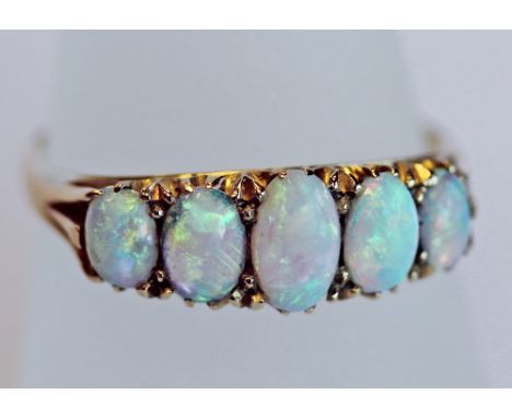 AN EDWARDIAN 18CT GOLD AND OPAL FIVE STONE RING with five graduating oval fiery opal cabochones, the shank marked 18, ring si