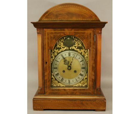 AN EDWARDIAN MAHOGANY BRACKET CLOCK with arched top and glazed door,  the silvered chapter ring of Roman hours within gilt sp