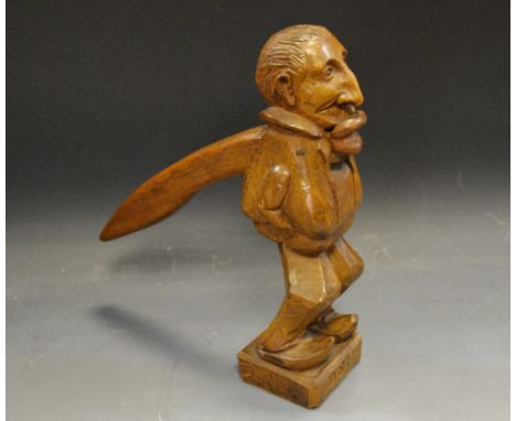 An early 20th century oak novelty table top lever-action figural nut cracker
