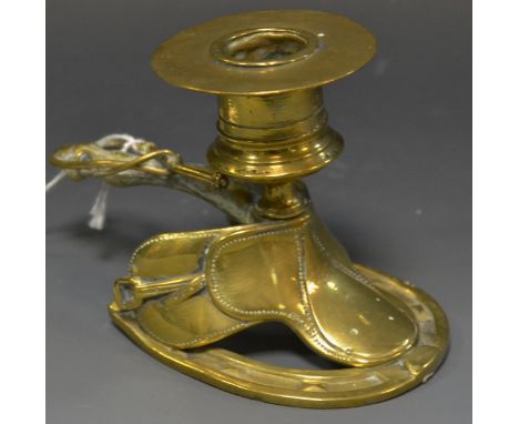 A 19th century brass novelty novelty chamber stick, cast as a saddle, fetlock and riding crop handle, cylindrical sconce with