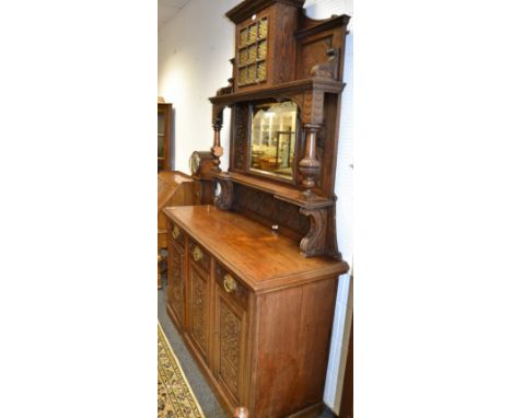 A 19th Century oak sideboard/ buffet profusely carved throughout oversailing cornice above a central cupboard of nine stained